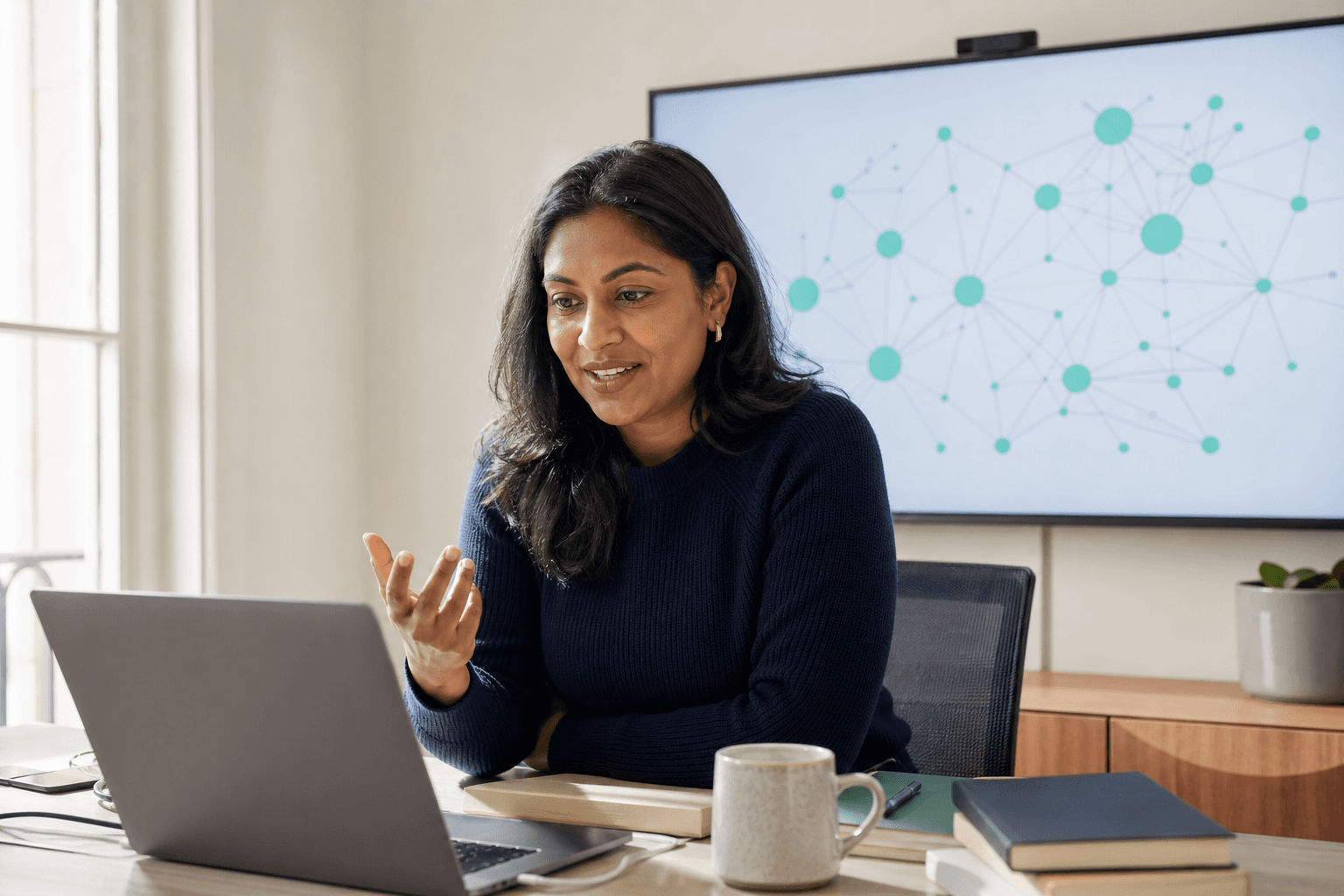 A colleague in conversation; the knowledge graph stays on the screen behind her.